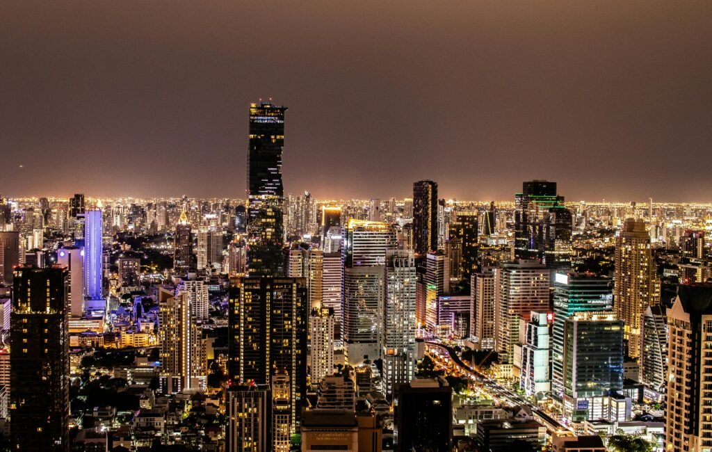 A vibrant night view of Bangkok's illuminated skyline featuring modern skyscrapers.